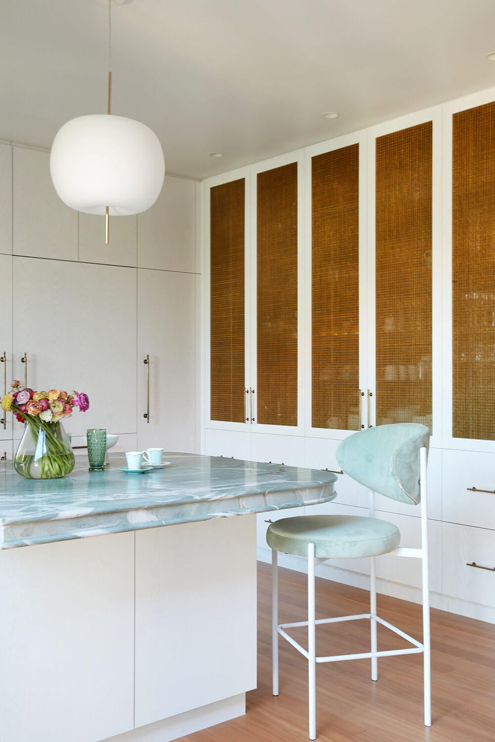 White kitchen joinery with woven panels and brass hardware — view 1