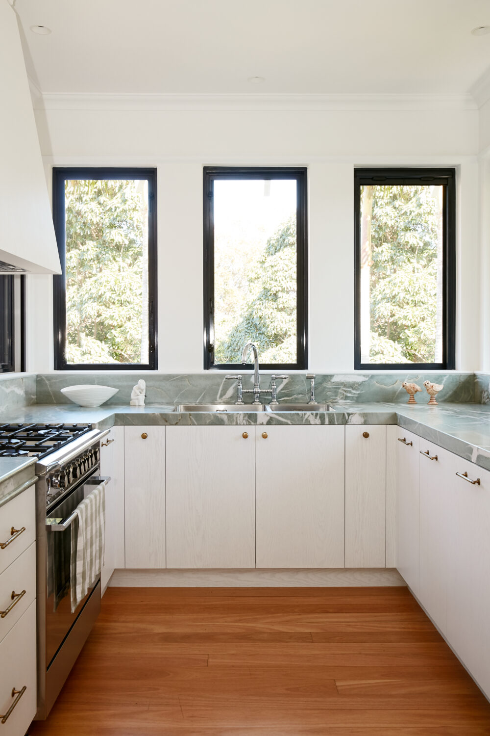 White kitchen joinery with woven panels and brass hardware — view 2