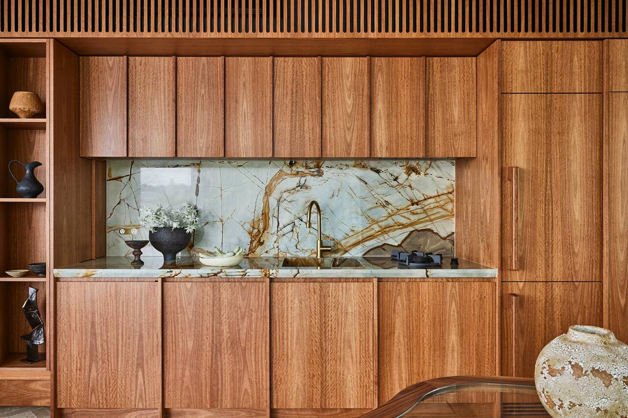 Warm timber kitchen with rust-veined stone — view 1