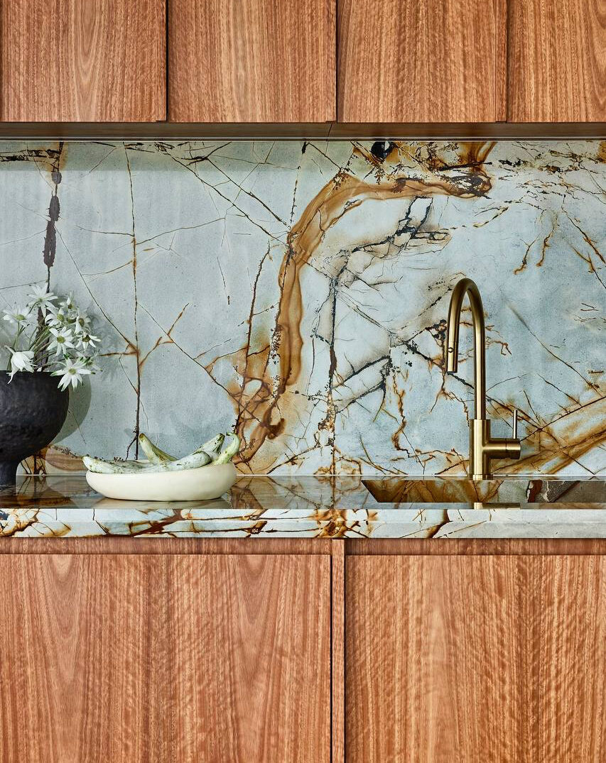 Warm timber kitchen with rust-veined stone — view 5